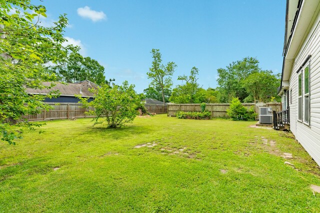 view of yard featuring central AC and a fenced backyard