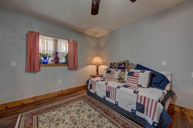 bedroom featuring a ceiling fan, baseboards, and wood finished floors