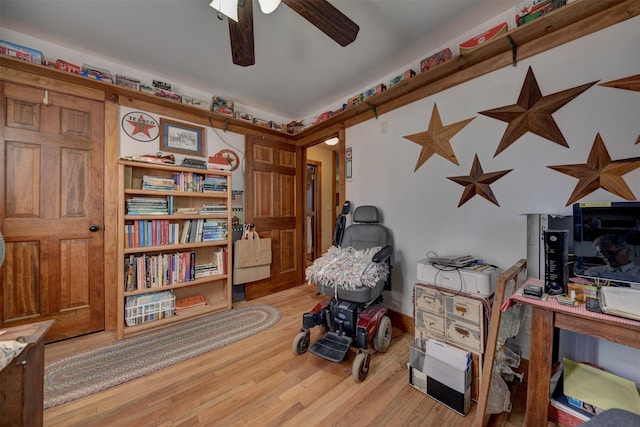 living area with a ceiling fan and wood finished floors