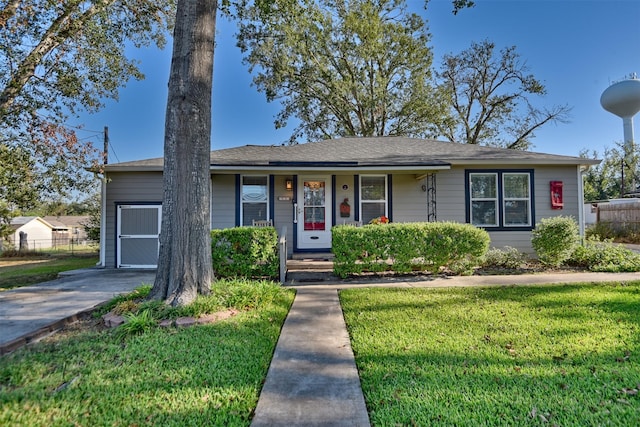 ranch-style house featuring fence and a front lawn