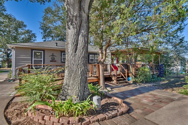 view of front of home with a wooden deck and a patio area