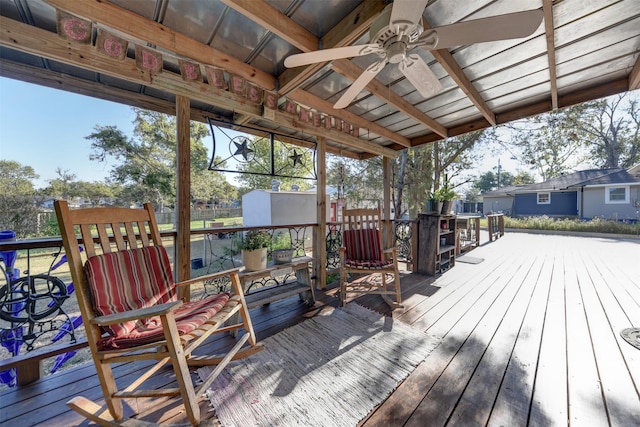 deck featuring an outdoor structure, ceiling fan, and a storage shed