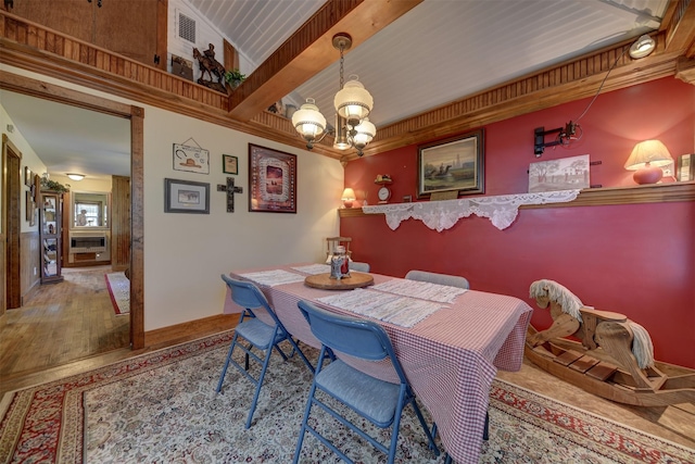 dining space with visible vents, wood finished floors, and an inviting chandelier