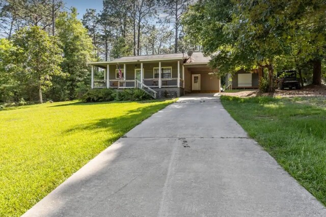 view of front of property featuring a carport, concrete driveway, a porch, and a front yard