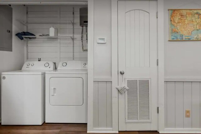 laundry room with electric panel, laundry area, visible vents, wood finished floors, and washer and clothes dryer
