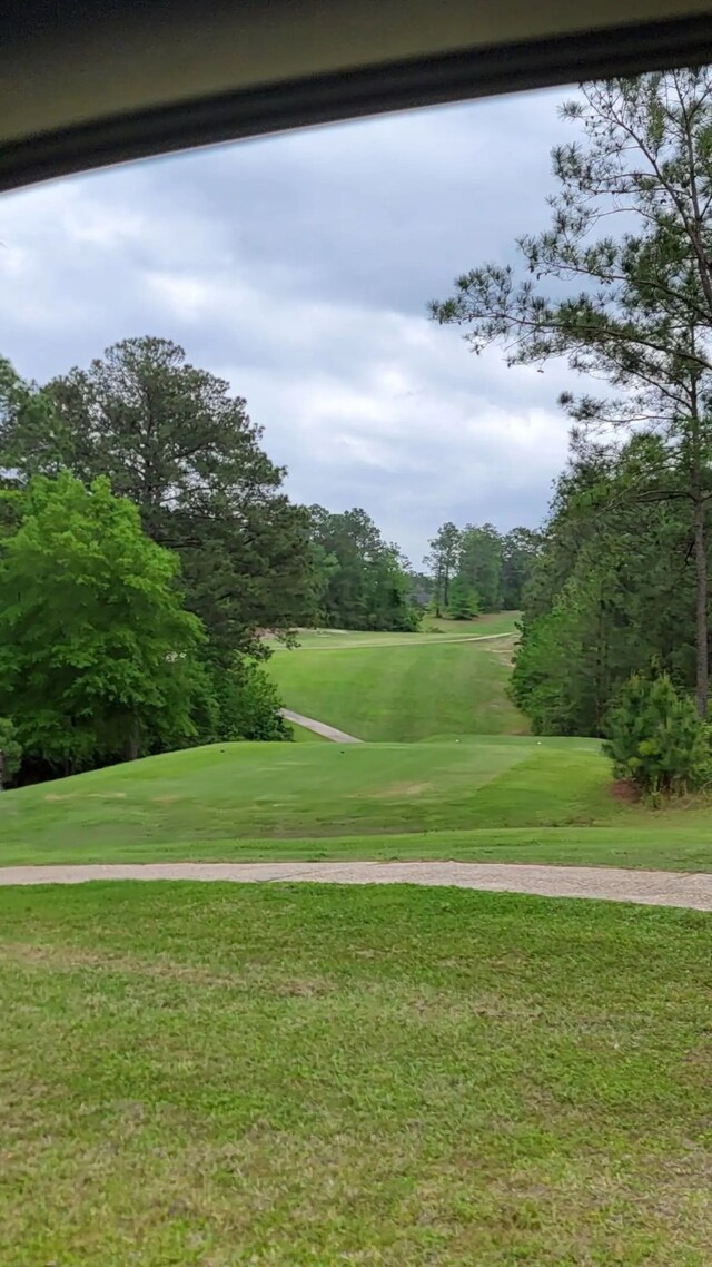 surrounding community with a yard and golf course view