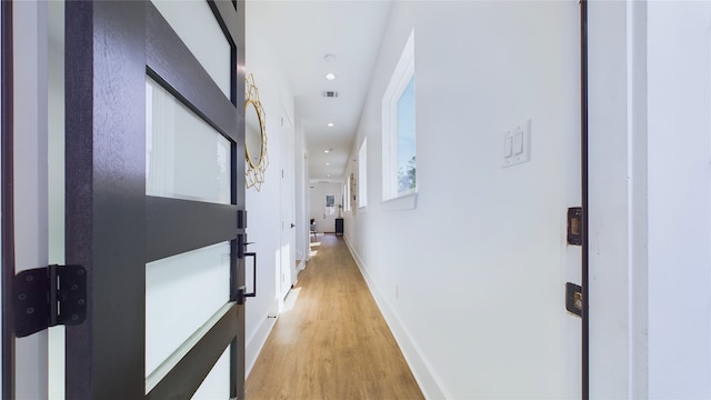 corridor featuring recessed lighting, light wood-style flooring, baseboards, and visible vents