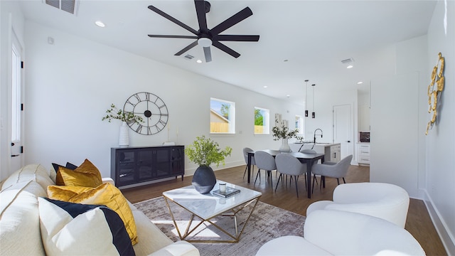 living room with visible vents, a ceiling fan, baseboards, and wood finished floors