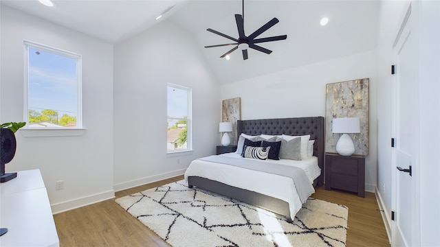 bedroom with baseboards, multiple windows, and wood finished floors