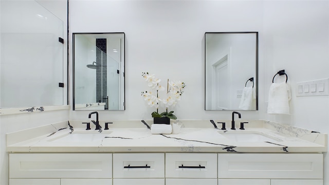 bathroom featuring double vanity, a sink, and a stall shower