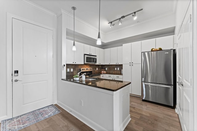 kitchen featuring crown molding, wood finished floors, and stainless steel appliances