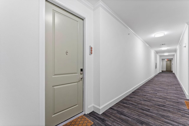 hall with baseboards, ornamental molding, and dark wood-style flooring