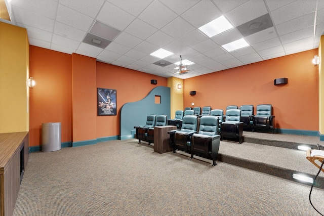 carpeted cinema room featuring baseboards, a paneled ceiling, and ceiling fan