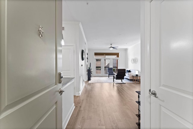 hallway featuring baseboards and light wood-style flooring