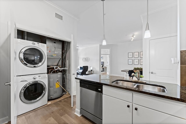 kitchen featuring stacked washer / dryer, crown molding, stainless steel dishwasher, wood finished floors, and a sink