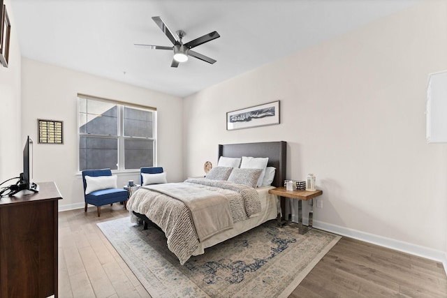bedroom with baseboards, ceiling fan, and wood finished floors