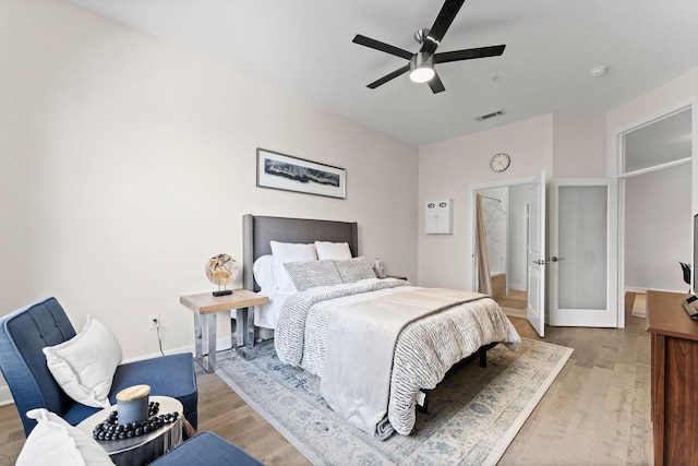 bedroom with baseboards, ceiling fan, light wood finished floors, and visible vents
