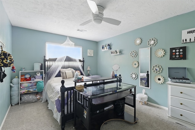 bedroom featuring carpet floors, visible vents, baseboards, a textured ceiling, and a ceiling fan