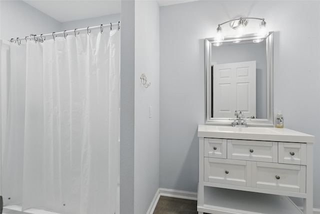 bathroom featuring vanity, baseboards, and curtained shower