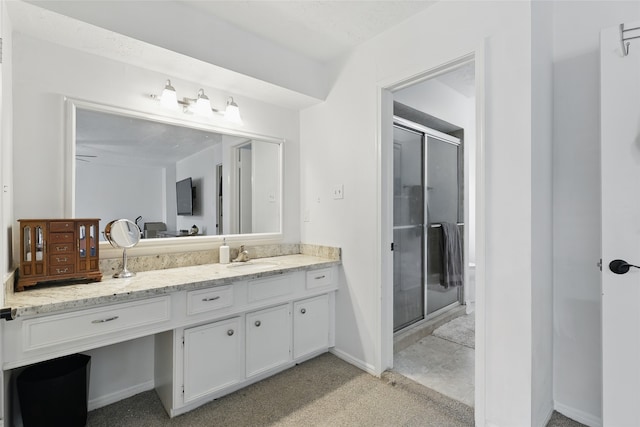 full bath featuring vanity, baseboards, and a shower stall