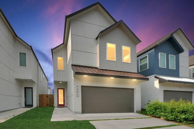 view of front of home with a garage, fence, a standing seam roof, metal roof, and driveway
