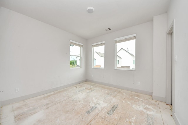 empty room featuring baseboards and visible vents