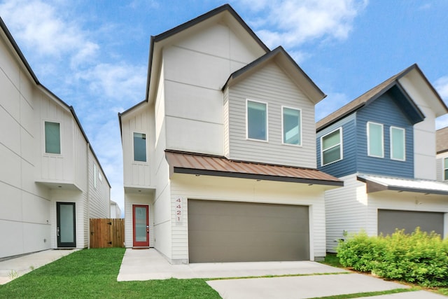 view of front of home featuring fence, a standing seam roof, metal roof, an attached garage, and driveway