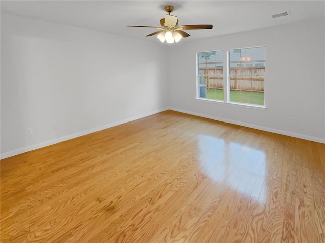 unfurnished room with baseboards, ceiling fan, light wood-type flooring, and visible vents