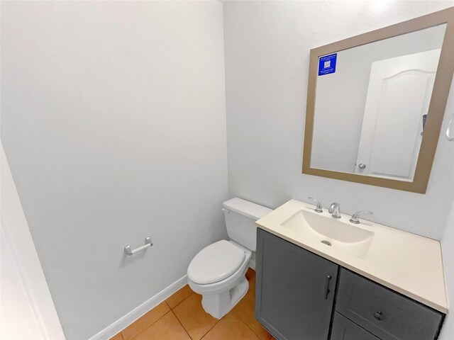 bathroom with toilet, baseboards, tile patterned flooring, and vanity