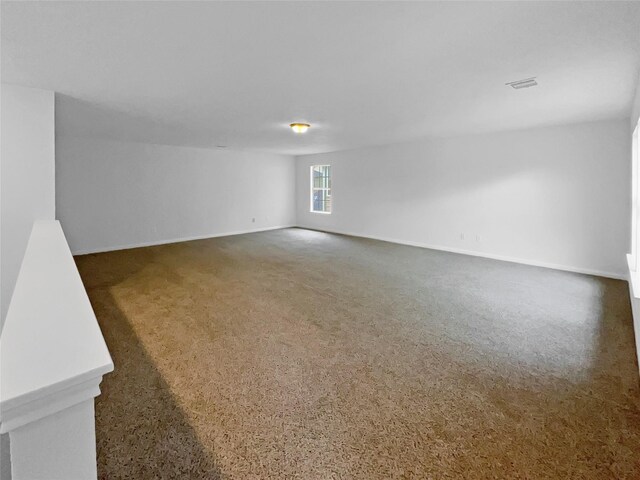 unfurnished room with baseboards and carpet flooring