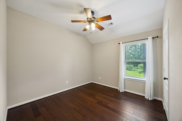 spare room with dark wood-type flooring, baseboards, ceiling fan, and vaulted ceiling