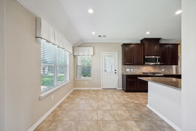 kitchen with stainless steel microwave, decorative backsplash, dark brown cabinetry, recessed lighting, and light tile patterned floors
