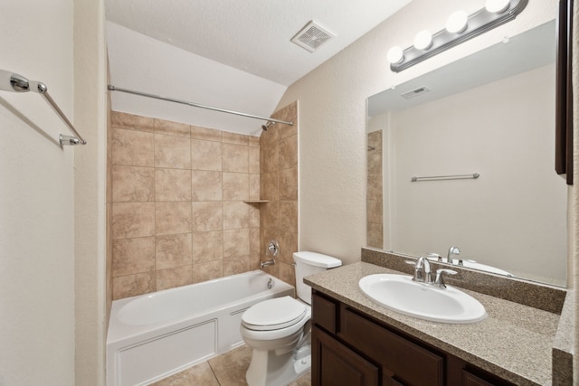 bathroom featuring toilet, tile patterned flooring, vanity, shower / tub combination, and a textured wall