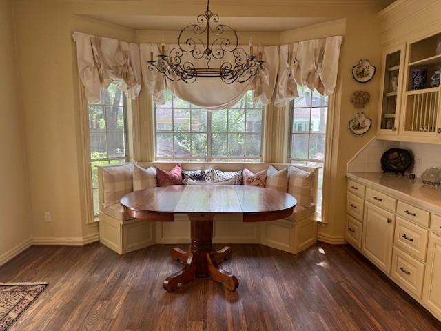 dining room with dark wood-style flooring, baseboards, a notable chandelier, and breakfast area