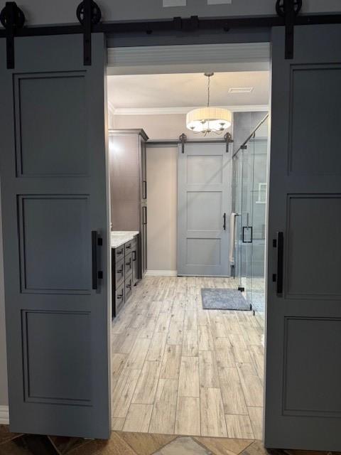 bathroom with crown molding, baseboards, a shower stall, and wood finished floors