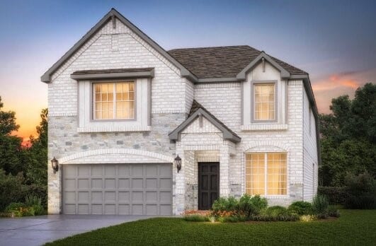 french country home featuring an attached garage and driveway