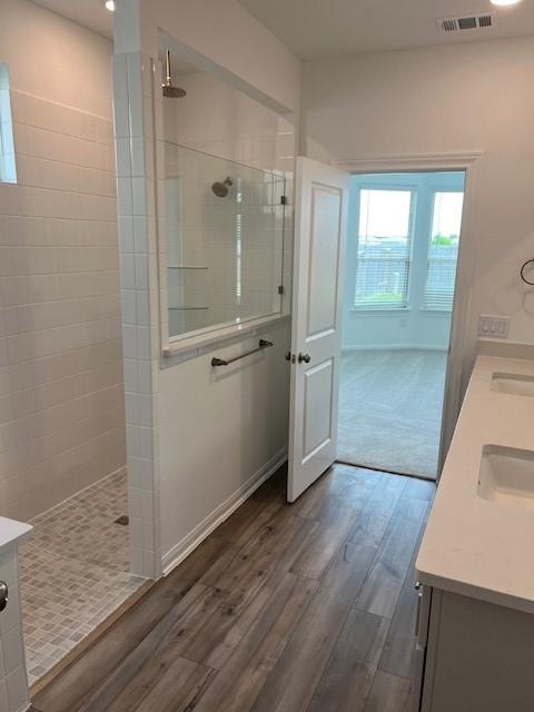 26712 Grandiflora Dr, Magnolia, TX 77355 - bathroom with double vanity, wood finished floors, and walk in shower