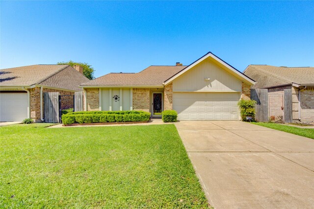 single story home with brick siding, an attached garage, a front yard, and concrete driveway
