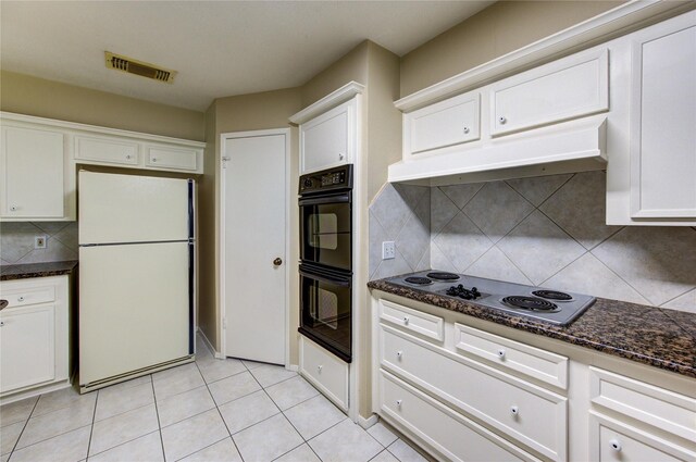kitchen with dobule oven black, visible vents, freestanding refrigerator, stainless steel electric stovetop, and white cabinetry
