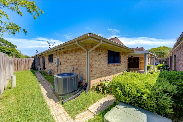 view of property exterior with a fenced backyard, a lawn, cooling unit, and brick siding