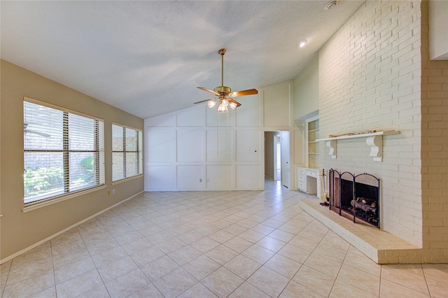 unfurnished living room featuring ceiling fan, a fireplace, light tile patterned floors, lofted ceiling, and a decorative wall