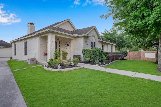 view of front of property with fence, a shingled roof, brick siding, a front yard, and a chimney