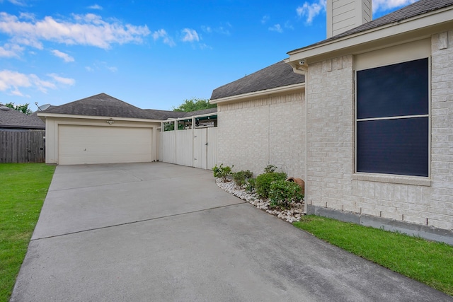 view of property exterior featuring a garage, fence, roof with shingles, a chimney, and concrete driveway