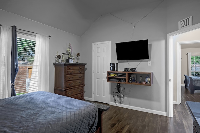 bedroom featuring baseboards, wood finished floors, and lofted ceiling