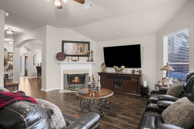 living area featuring visible vents, wood finished floors, ceiling fan, arched walkways, and vaulted ceiling