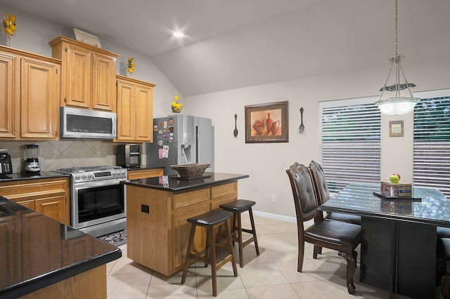 kitchen featuring light tile patterned flooring, a kitchen island, tasteful backsplash, appliances with stainless steel finishes, and vaulted ceiling