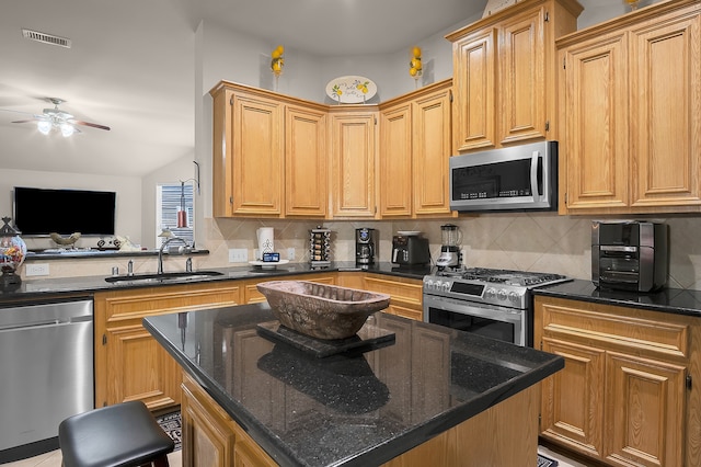 kitchen with a sink, ceiling fan, backsplash, and stainless steel appliances