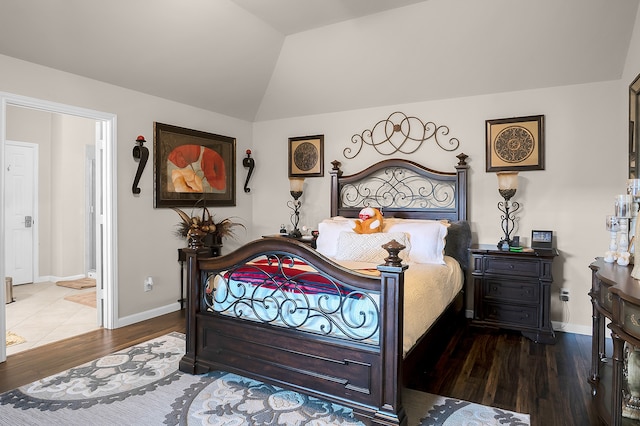 bedroom with baseboards, wood finished floors, and vaulted ceiling