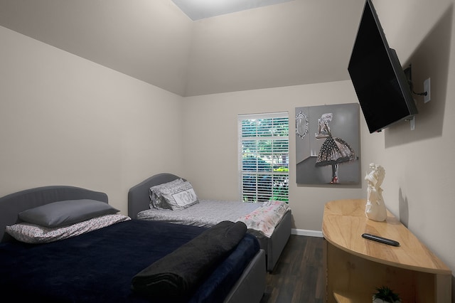 bedroom with baseboards, lofted ceiling, and dark wood-type flooring