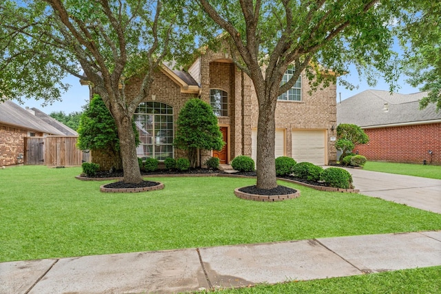 5211 Bur Oak Dr, Pasadena, TX 77505 - traditional home featuring fence, an attached garage, brick siding, a front yard, and driveway